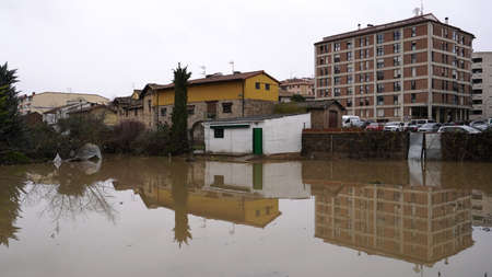 the river drowns private houses, flooding, residential houses in the water. the village of Villava, Navarra provinces, Spain. filmed December 12, 2021のeditorial素材