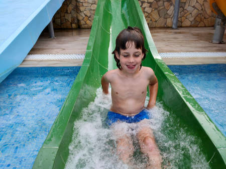 child going down the slide in the poolの写真素材