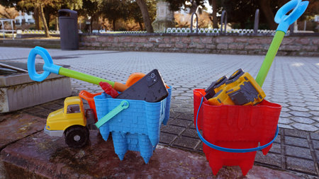 A mobile phone among the toys of the kids on the beachの写真素材