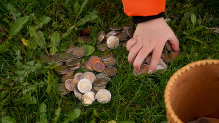 the boy is engaged in geocaching. the boy found a cache, a wooden box with coins
