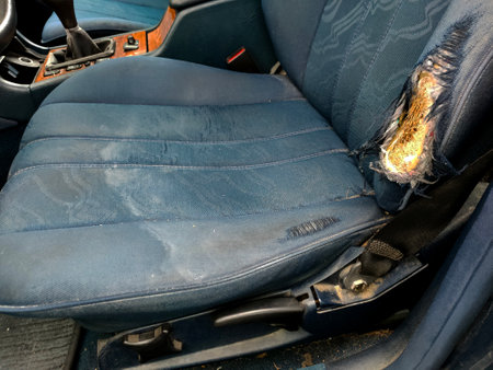 blue car seat with torn upholstery, from long useの写真素材
