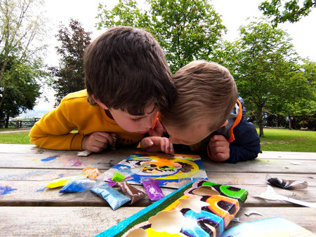 children in the yard, painting a picture, with powder paints, sitting at a wooden table. summer camp for kidsの写真素材