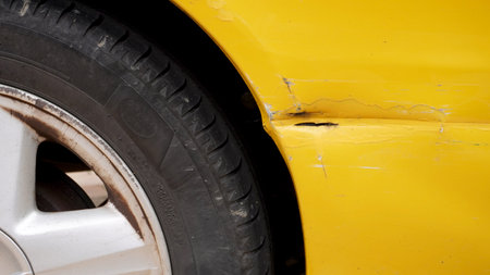 a deep scratch on the body of a yellow car after a repair attempt, in an impromptu wayの写真素材