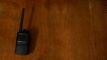 walkie-talkie lie on a dark brown oak table. background, place for an inscriptionの写真素材