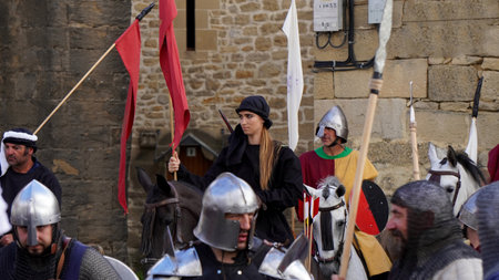 a gathering of people in theatrical costumes from the Medieval period in the village square: Muez (Navarra) EspaÃ±a. July 1, 2023. battle setting: Valdejunqueraのeditorial素材