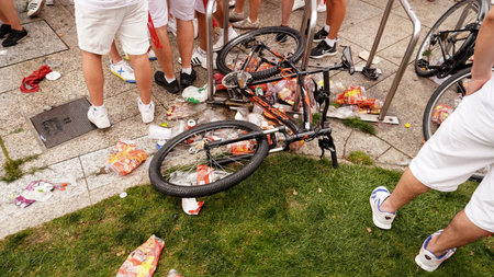 Plastic garbage, from alcoholic beverages, accumulates under a bicycle lying on the street Festivals: San Fermin. Pamplona Navarra July 6, 2023のeditorial素材
