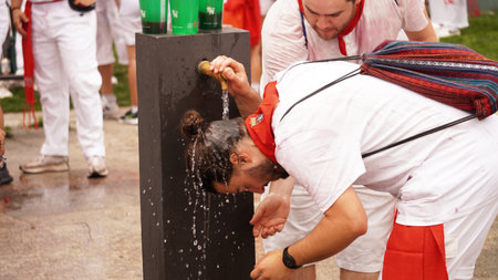 A man puts his head under a fountain with water at the Opening of San Fermin. Cupinazo in the Plaza del Castillo Pamplona (Navarara) July 6, 2023のeditorial素材