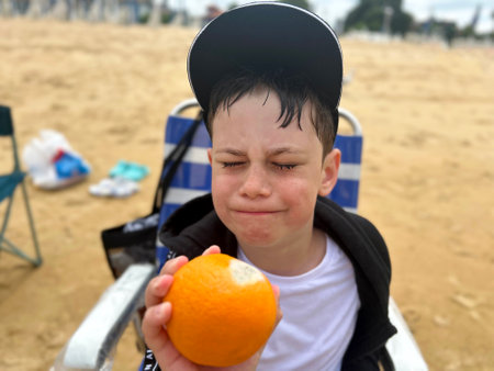emotionally upset face of a child after he saw that his orange was covered with moldの写真素材