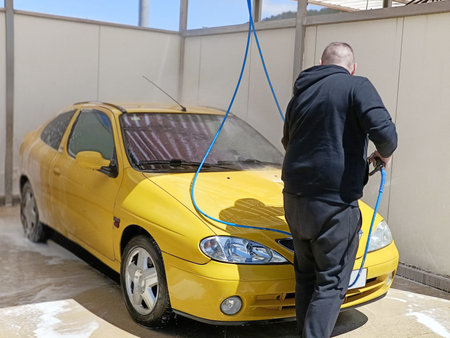 man washing a car at a car washの写真素材