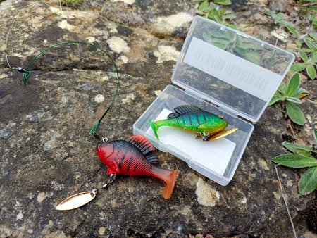 small fish of red and green colors: rubber bait with a hook hidden in the fins. bait for catching predatory fish in ponds with thick grassの写真素材