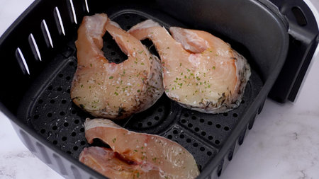 Prepare fish in air fryer, fish pieces on fryer trayの写真素材
