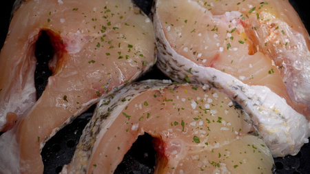 chopped fish pieces close-up, sprinkled with salt and parsleyの写真素材