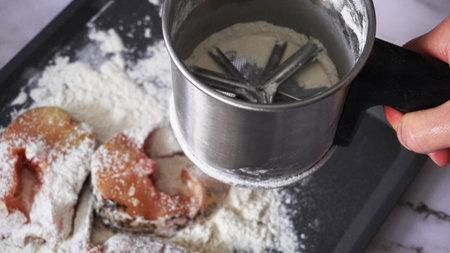 First sprinkle the fish with flour for further fryingの写真素材