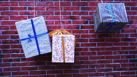 Gift boxes hanging on a brickの写真素材