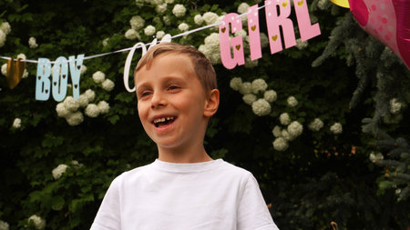 A child's face light up with joy upon discovering he's going to have a sister. gender reveal partyの写真素材
