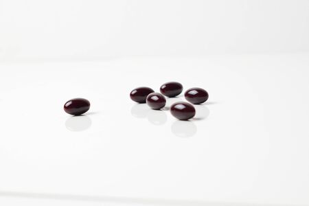 Astaxanthin capsules scattered on a white background.の写真素材