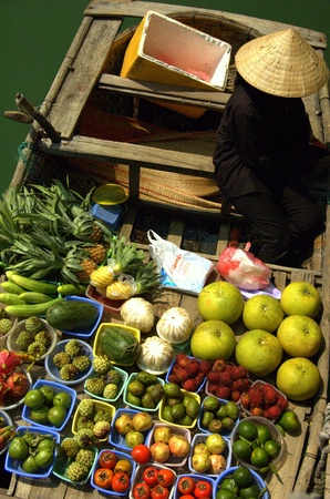 Selling fruits and vegetables on a floating boat in Halong bay, Hanoi, Vietnamのeditorial素材