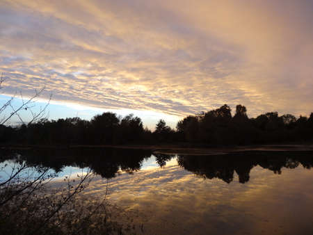Sunset on the lake. The sky is reflected in the water.の写真素材