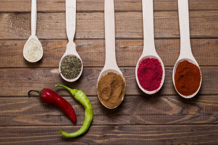 Spices in spoons on wooden table with hopの写真素材