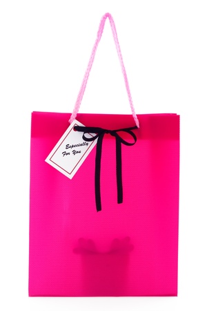 Pink gift bag with small card and a silhouette of a present inside isolated on white backgroundの写真素材