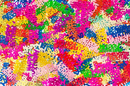 Colourful background of multicolored happy birthday confetti pieces の写真素材