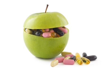 Green apple filed with colourful pills, isolated on white background.の写真素材