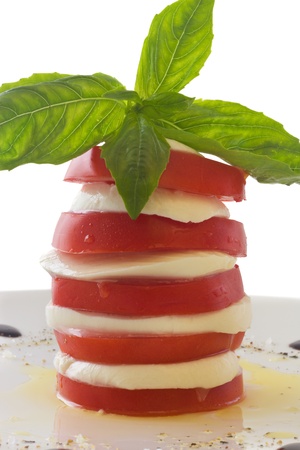 Tower of mozzarella and tomato salad with basil leaf, isolated on white の写真素材
