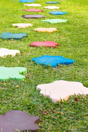 Colorful Stone block walk path in the park with green grass background の写真素材