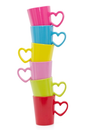Stack of colorful cups with heart element isolated on white background の写真素材