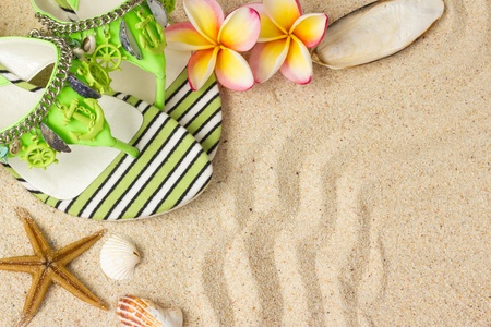 Green Sandals, seashells, starfish and frangipani on sand の写真素材