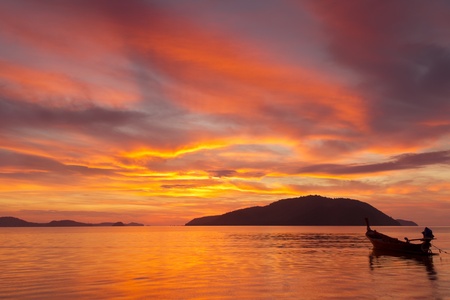Beautiful Sunrise in Phuket, Thailand, with far island and a fishing boat silhouette の写真素材