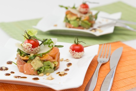 Avocado and salmon salad on square plate の写真素材