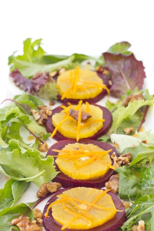 Beetroot and orange salad with walnuts and orange zest, isolated on white backgroundの写真素材