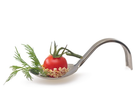 Cherry tomato with dill on serving spoon, isolatedの写真素材