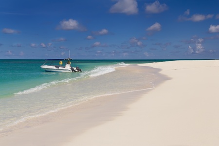 Tropical sandy beach at summer sunny day, with boat on backgroundの写真素材