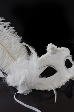 Carnival white mask with feather on black  backgroundの写真素材
