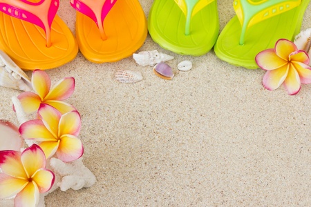 Flip Flops in the sand with shells and frangipani flowers  Summertime on beach concept の写真素材