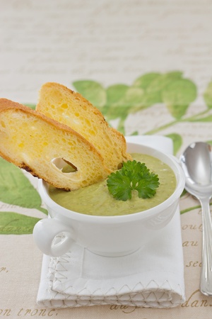 Pea cream soup with parsley and croutons, on white napkinの写真素材