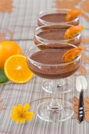 Chocolate mousse with slices of preserved oranges, yellow flower, and spoonの写真素材