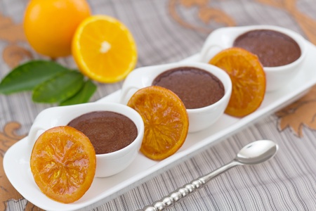 Chocolate mousse with slices of preserved oranges and spoon on the sideの写真素材