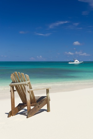 Beach chair on white sand beach with white boat on background  Summer Holiday backgroundの写真素材