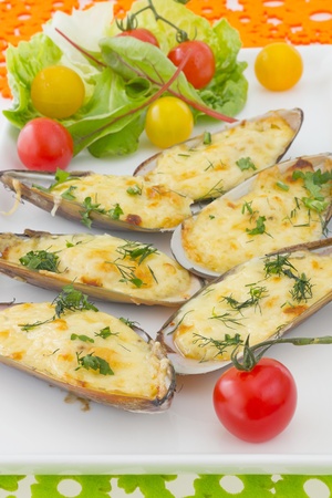 Baked Mussels under Cream Cheese Sauce  Garnished with dill and Cherry Tomato salad, on colorful backgroundの写真素材