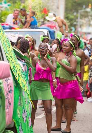 Victoria, Seychelles - February 9, 2013: Group of young women in vibrant green and pink outfit dancing on streets of Victoria, on Parade of Seychelles international Carnivalのeditorial素材