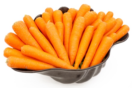 Large black bowl full of ripe and fresh carrots, isolatedの写真素材
