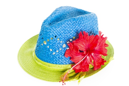 Blue and green summer panama straw hat with red hibiscus flower isolated on whiteの写真素材