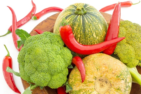 Vegetables in a bowl as a pumpkins, broccoli and red chili peppers,  isolated on whiteの写真素材