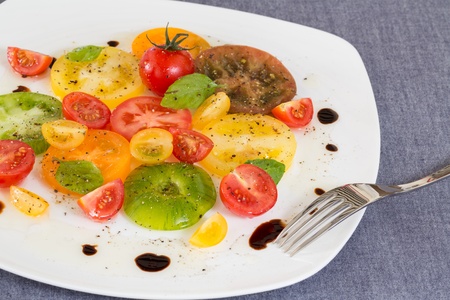 Colorful Tomato salad with fork on sideの写真素材