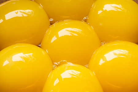 Seven egg yolks in capper bowl, close upの写真素材