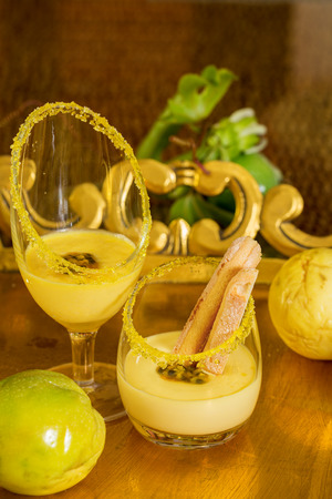 Two glasses of passion fruit dessert with fresh fruit on the side  の写真素材