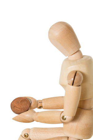 Sitting Wooden mannequin holding one cent coinの写真素材